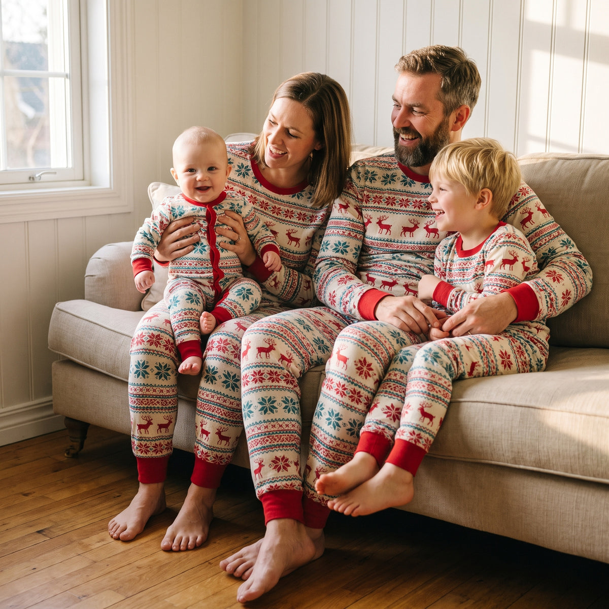 Famille réunie sur le canapé en pyjamas de Noël écrus et sarcelle à motifs rennes assortis