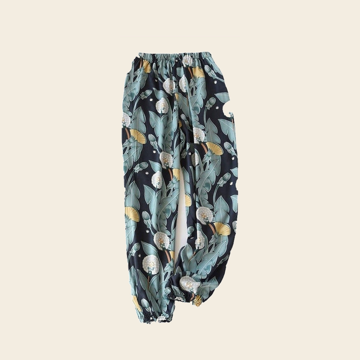 Pantalon cocooning femme bleu nuit à feuillage vert, sur fond beige