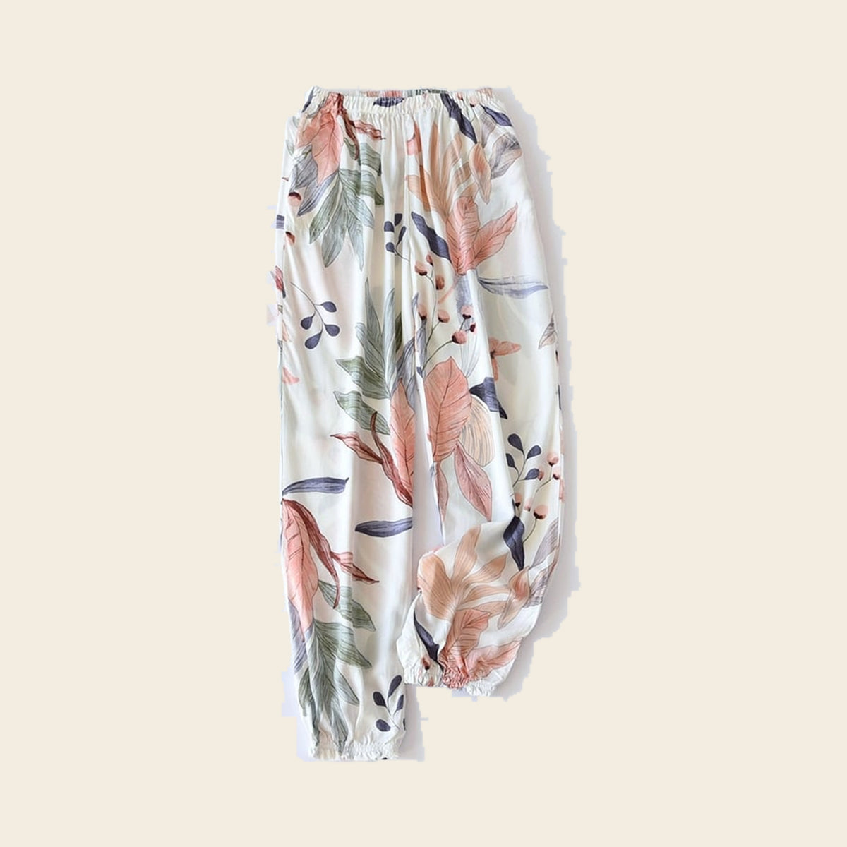 Pantalon cocooning femme ivoire à feuillage corail, sur fond beige