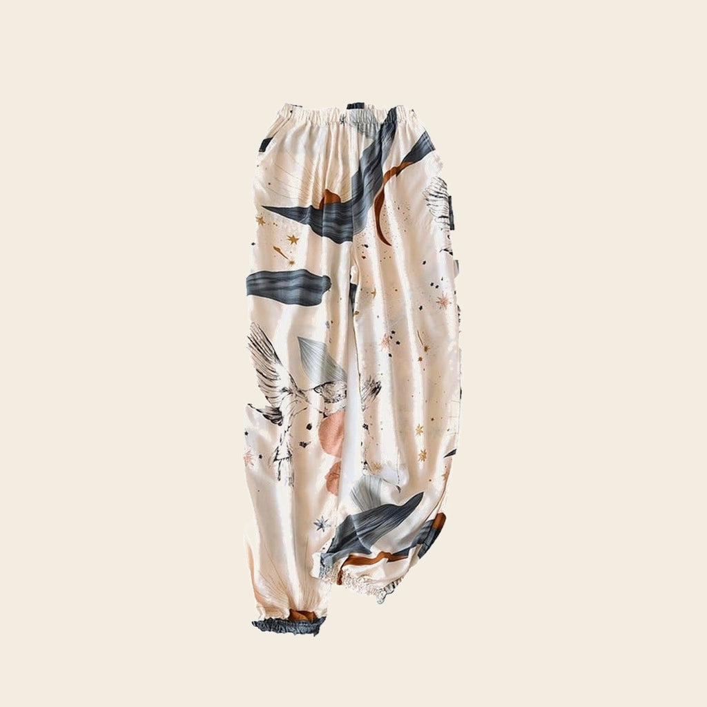 Pantalon cocooning femme ivoire à grues et astres, sur fond beige