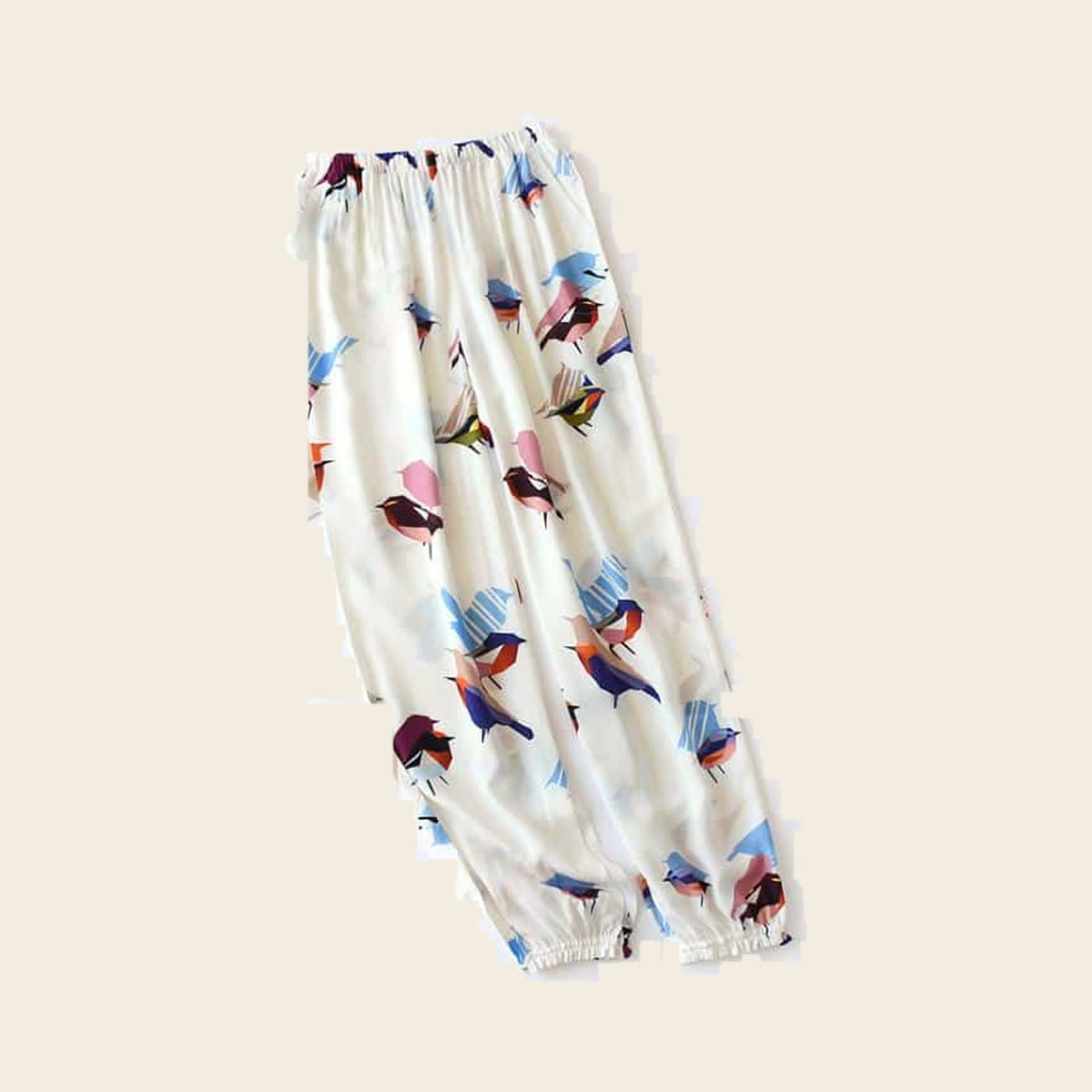 Pantalon cocooning femme ivoire à oiseaux colorés, sur fond beige
