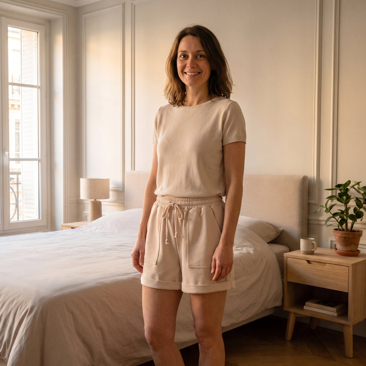 Femme en short beige taille haute dans une chambre lumineuse