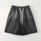 Bermuda en jean noir à taille élastiquée présenté à plat