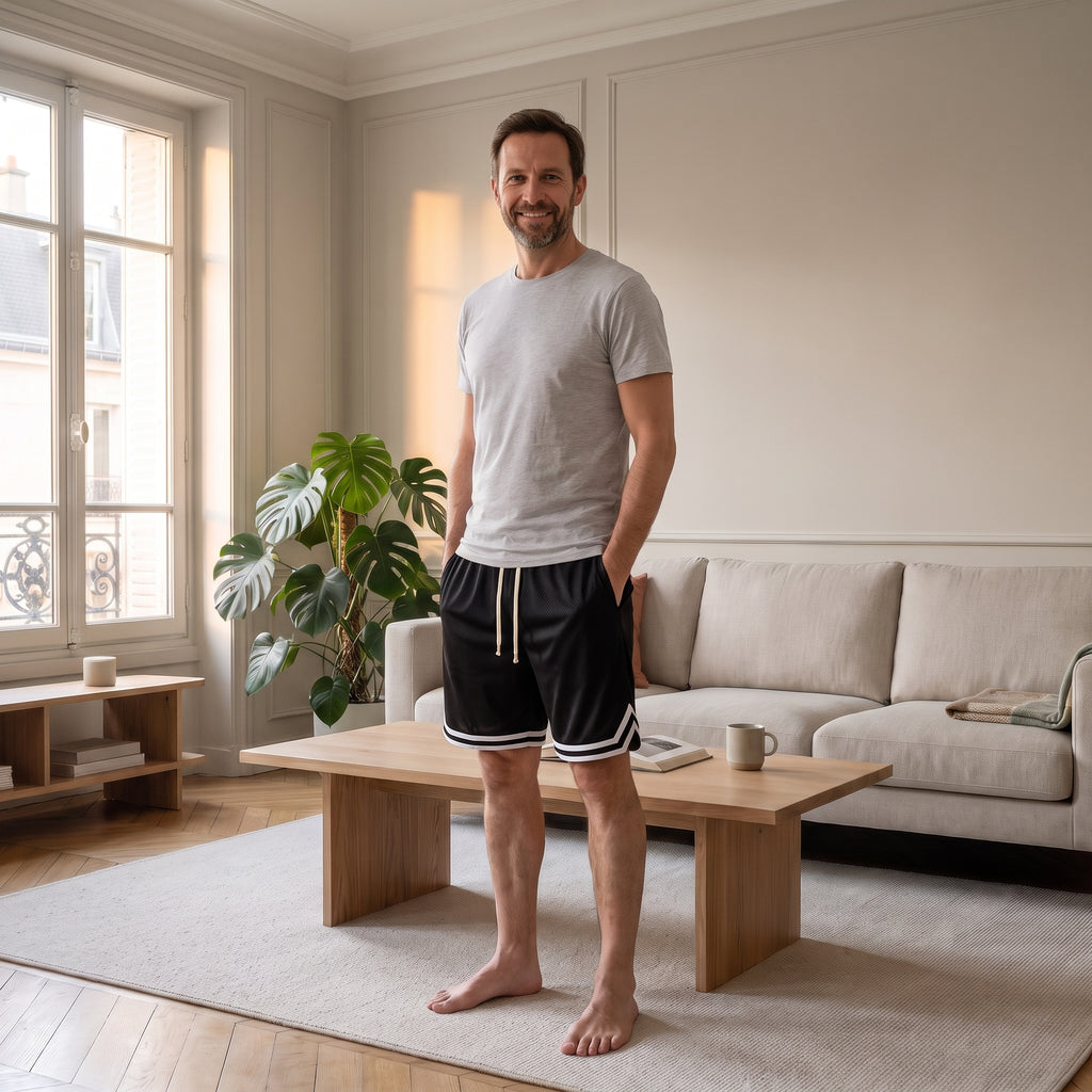 Homme portant le short de sport noir dans un salon lumineux