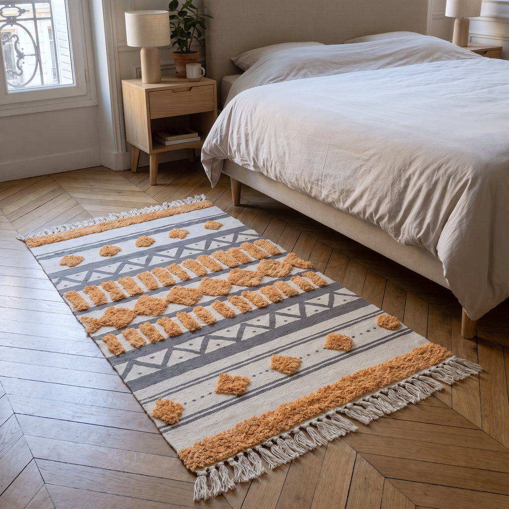 Tapis d'inspiration orientale déroulé le long du lit dans une chambre parisienne