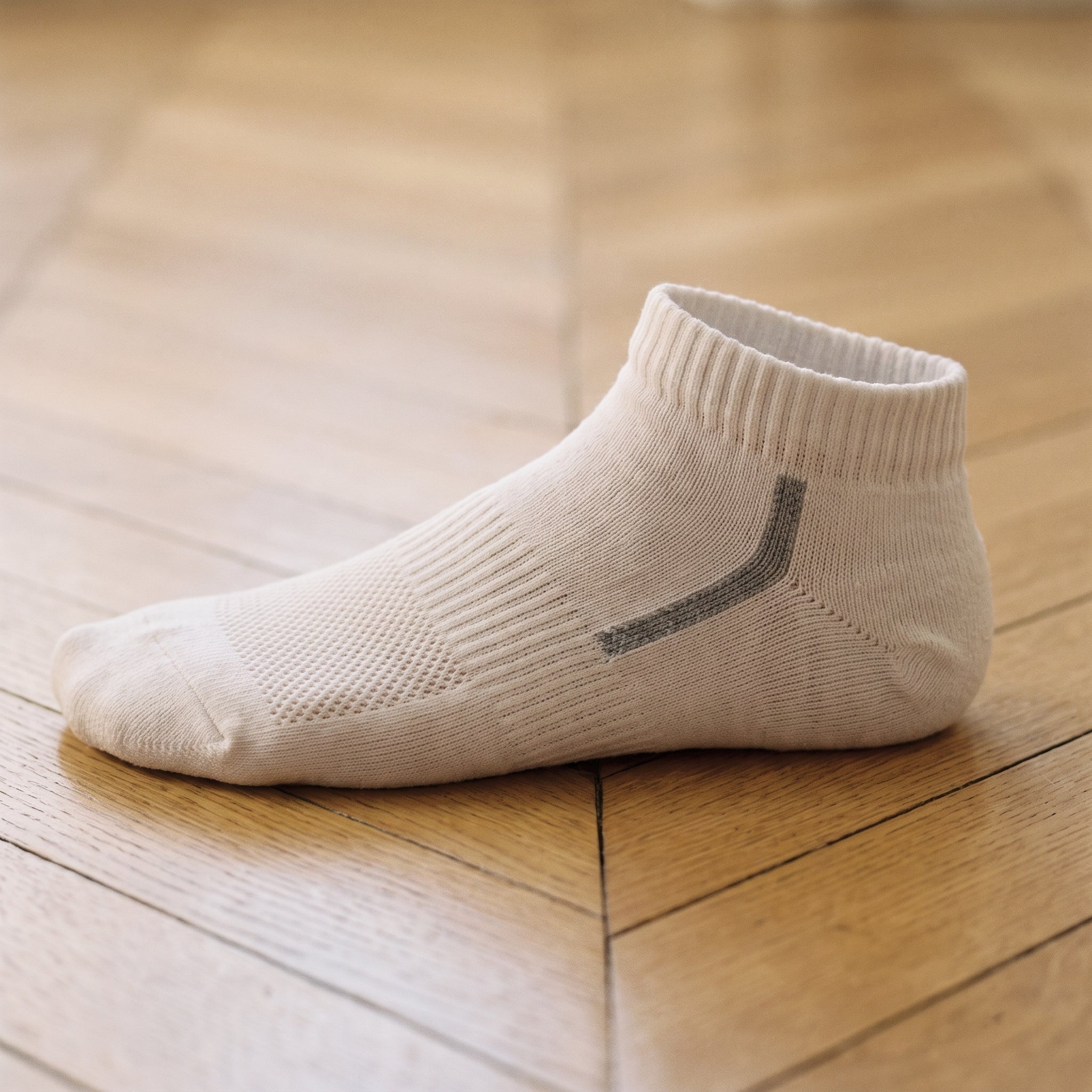 Gros plan sur une socquette blanche à chevron gris, maille ajourée sur le dessus du pied Image
