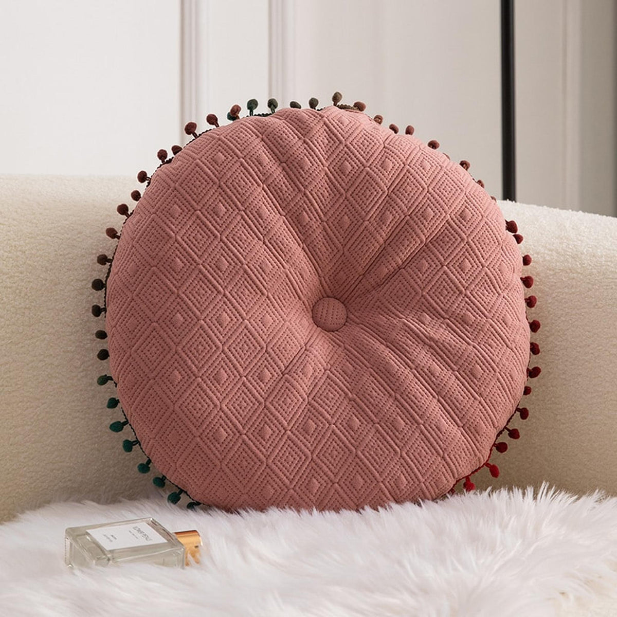 Coussin rond à pompons, détail des motifs et des pompons