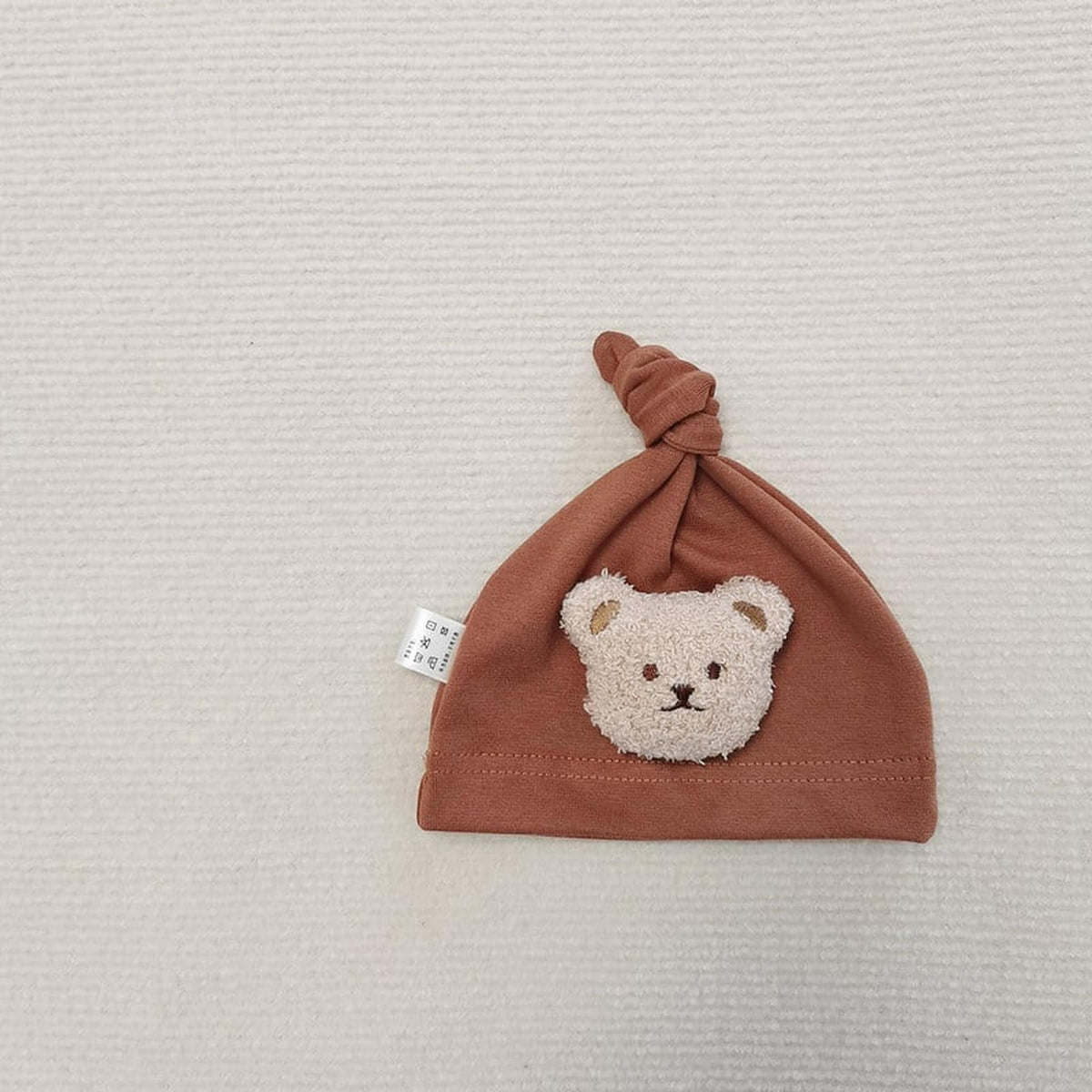 Gros plan de l'ourson en peluche en relief du bonnet bébé