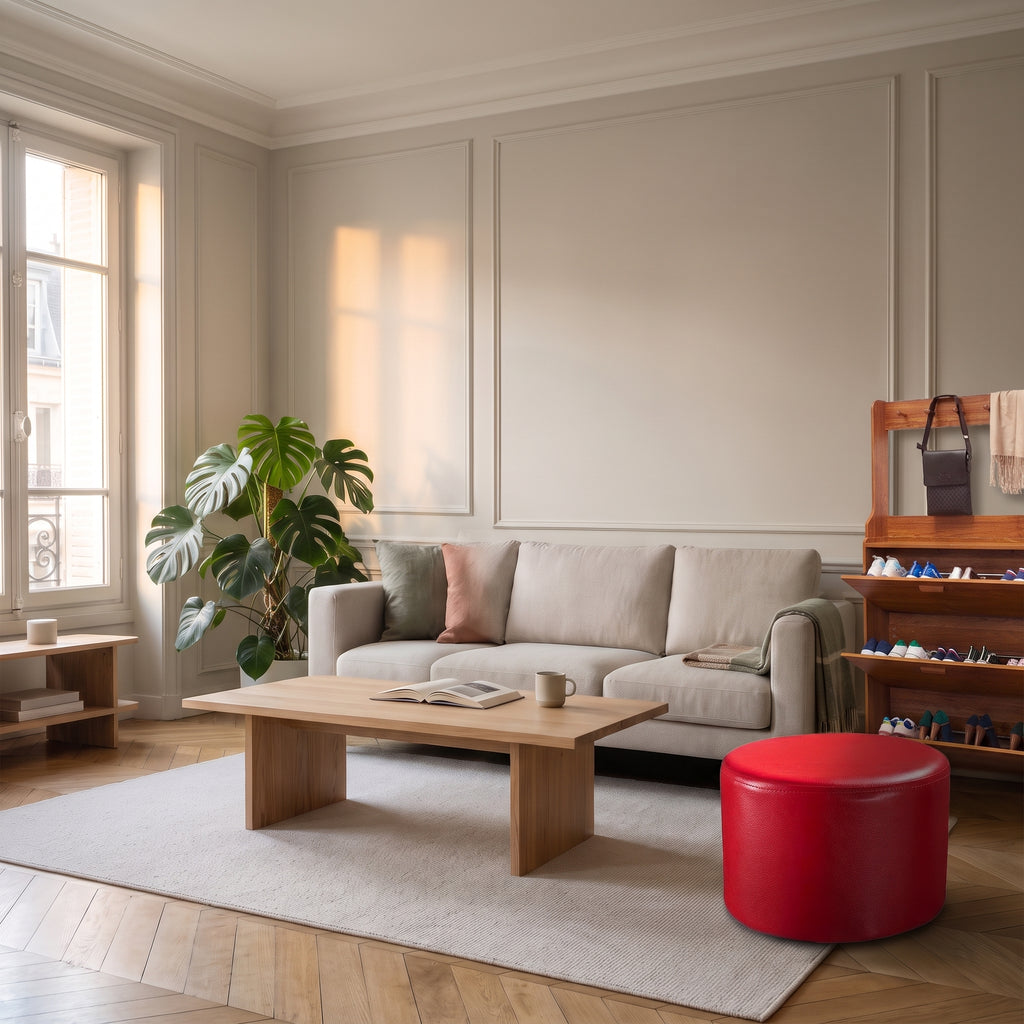 Pouf rond en cuir synthétique rouge dans un salon, à l'échelle