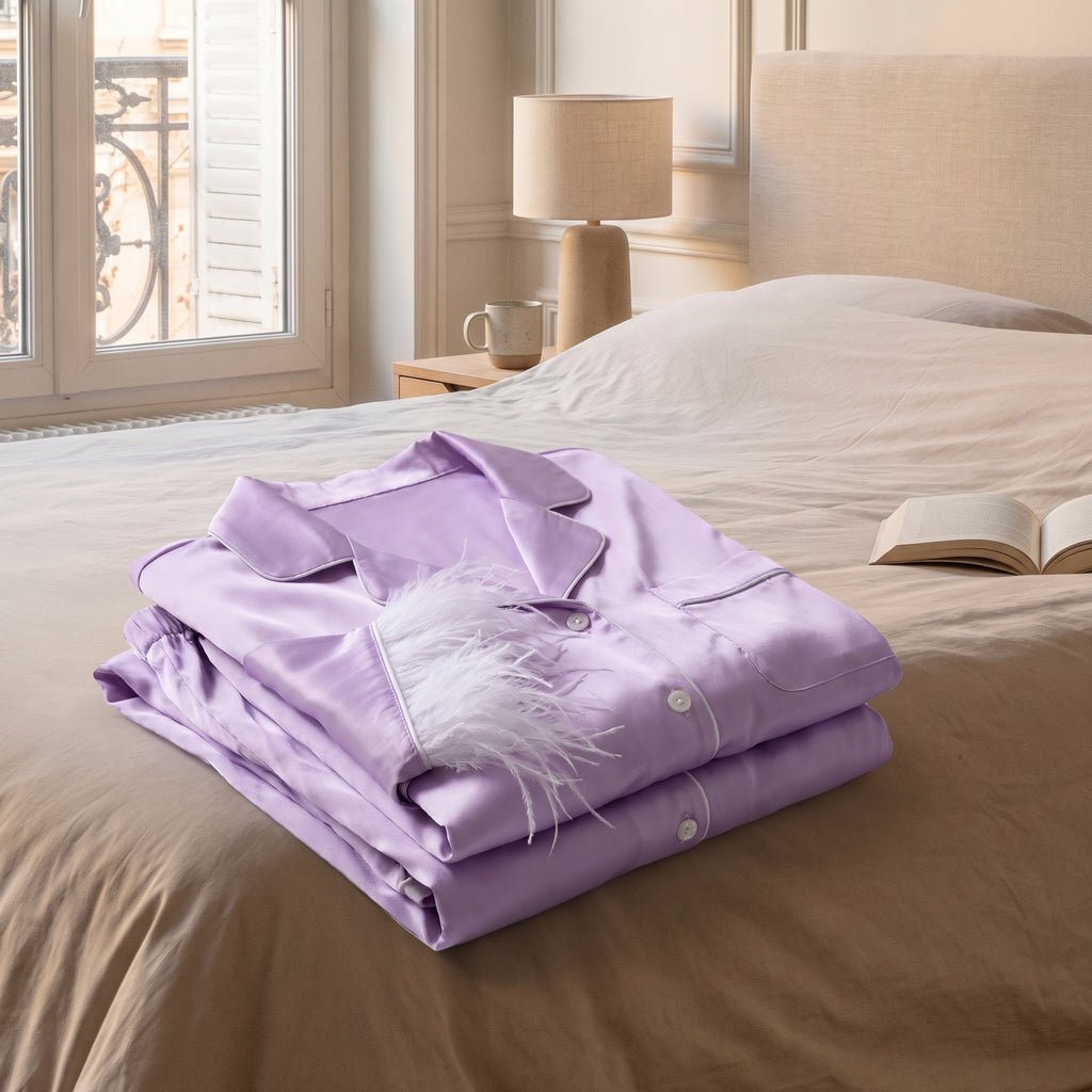 Pyjama d'été à plumes violet clair plié au pied du lit
