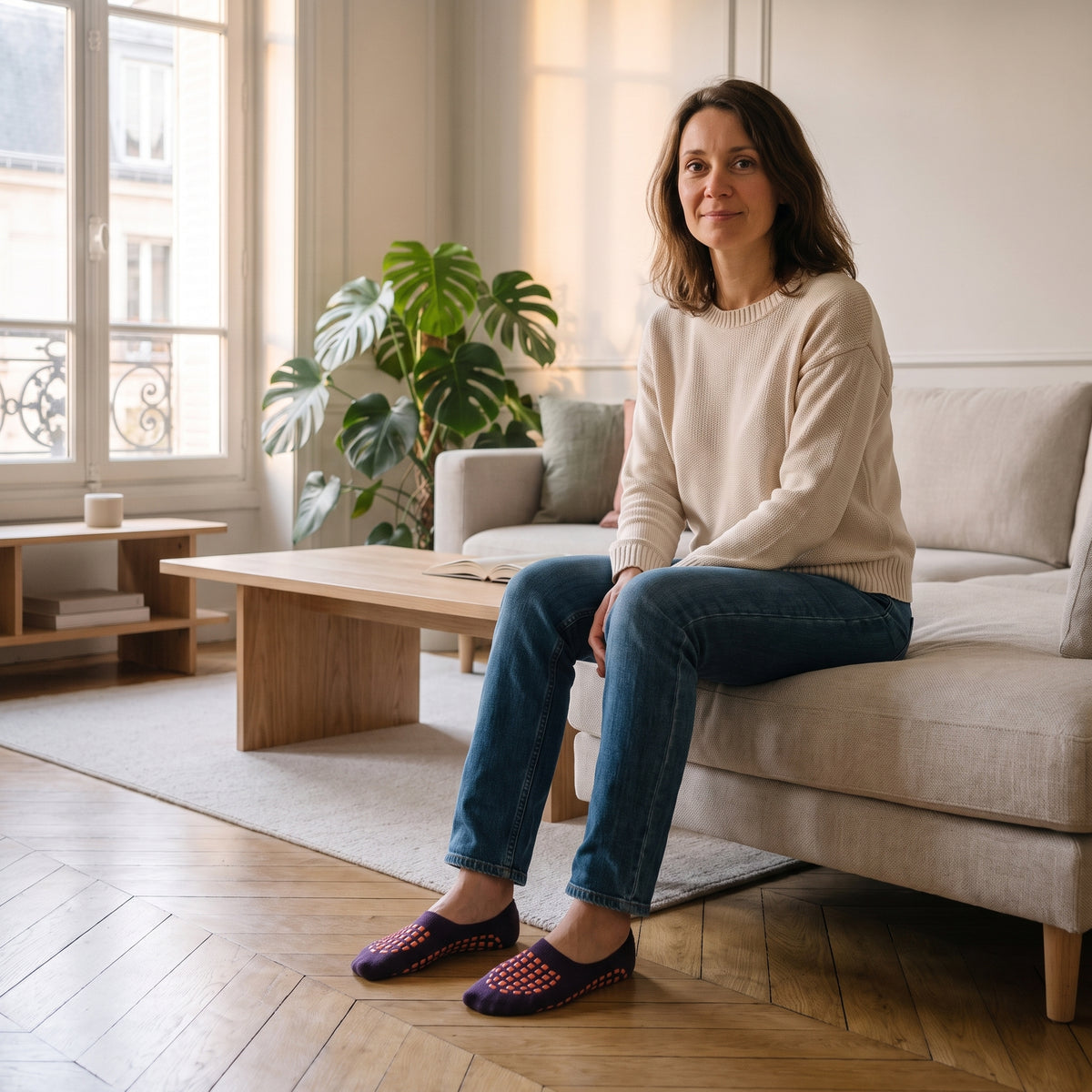 Chaussettes antidérapantes violettes portées aux pieds dans un salon