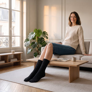 Chaussettes noires en maille torsadée portées aux pieds dans le salon
