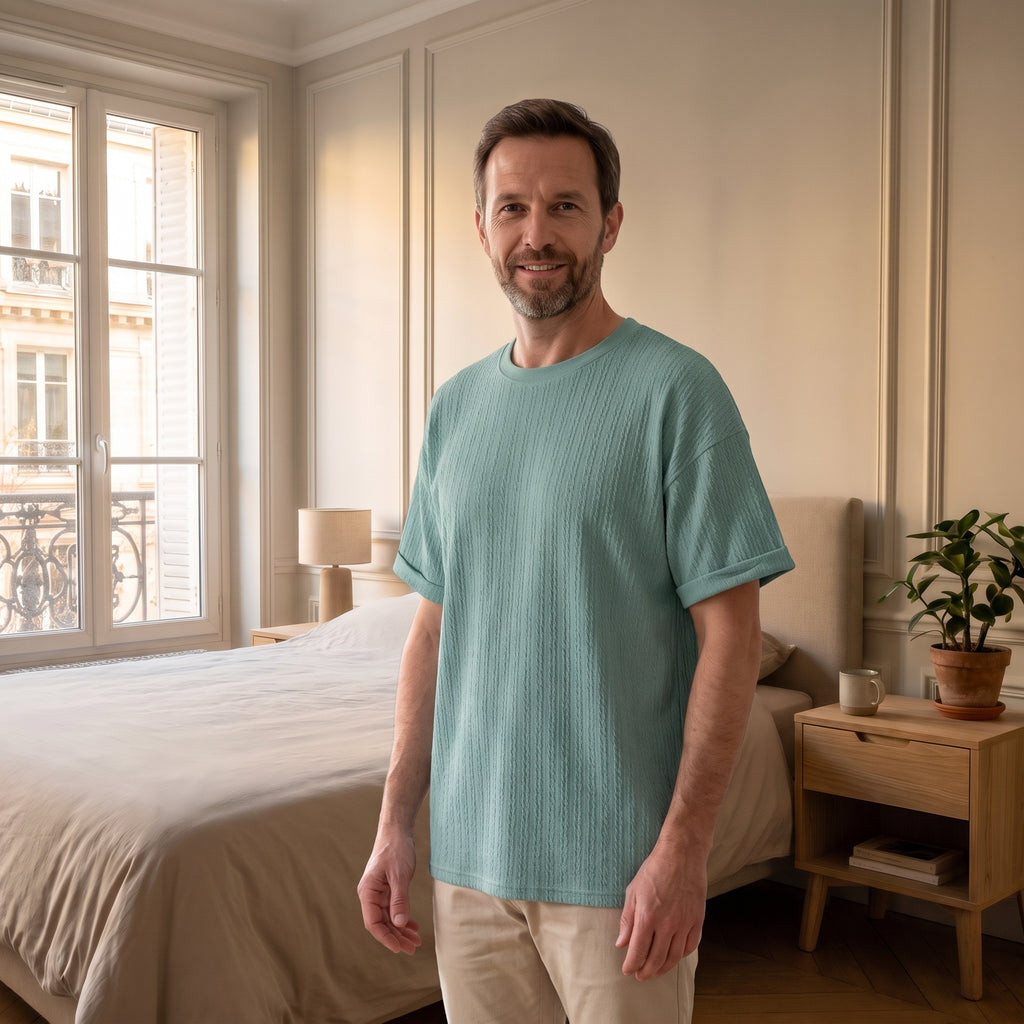 T-shirt cocooning maille torsadée vert, porté par un homme dans sa chambre