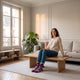 Chaussettes à pompons violettes portées aux pieds dans un salon