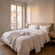Housse de couette blanche en coton, unie et lisse, sur un lit fait dans une chambre