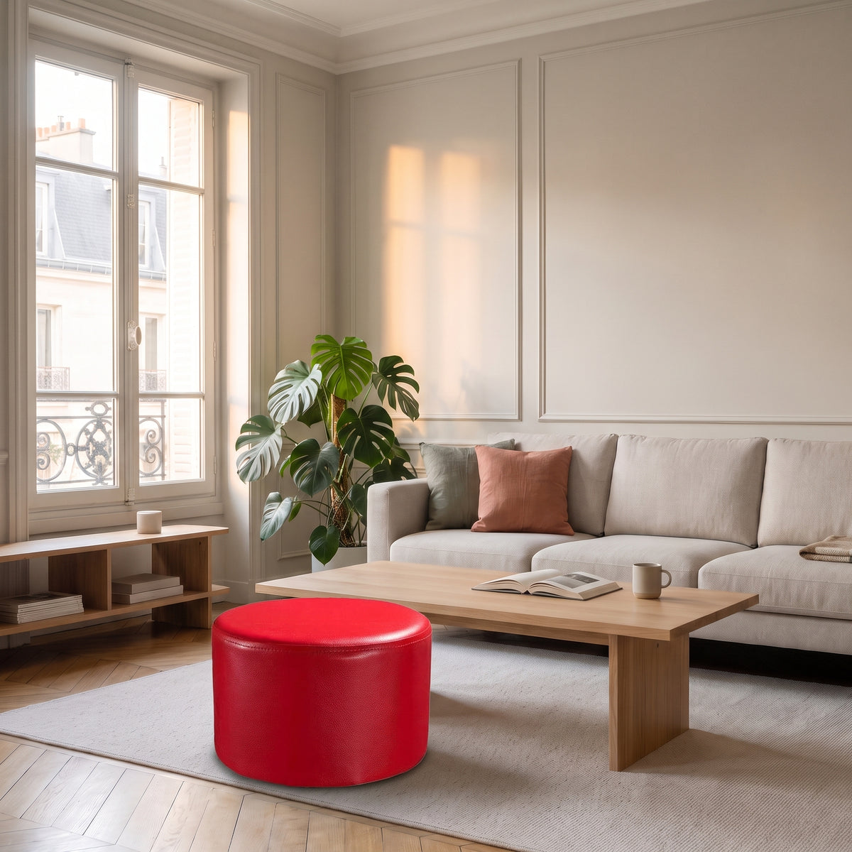 Pouf rond en cuir synthétique rouge posé au sol dans un salon