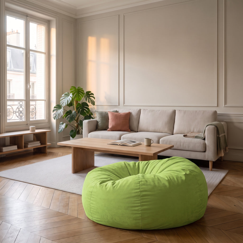 Housse de pouf immense verte posée au sol du salon, devant le canapé en tissu clair