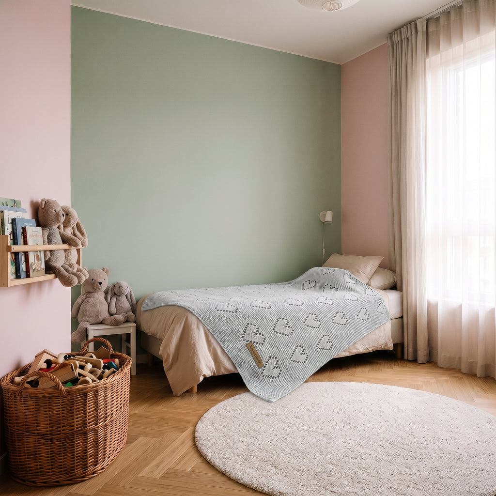 Couverture bébé gris clair posée sur un lit d'enfant