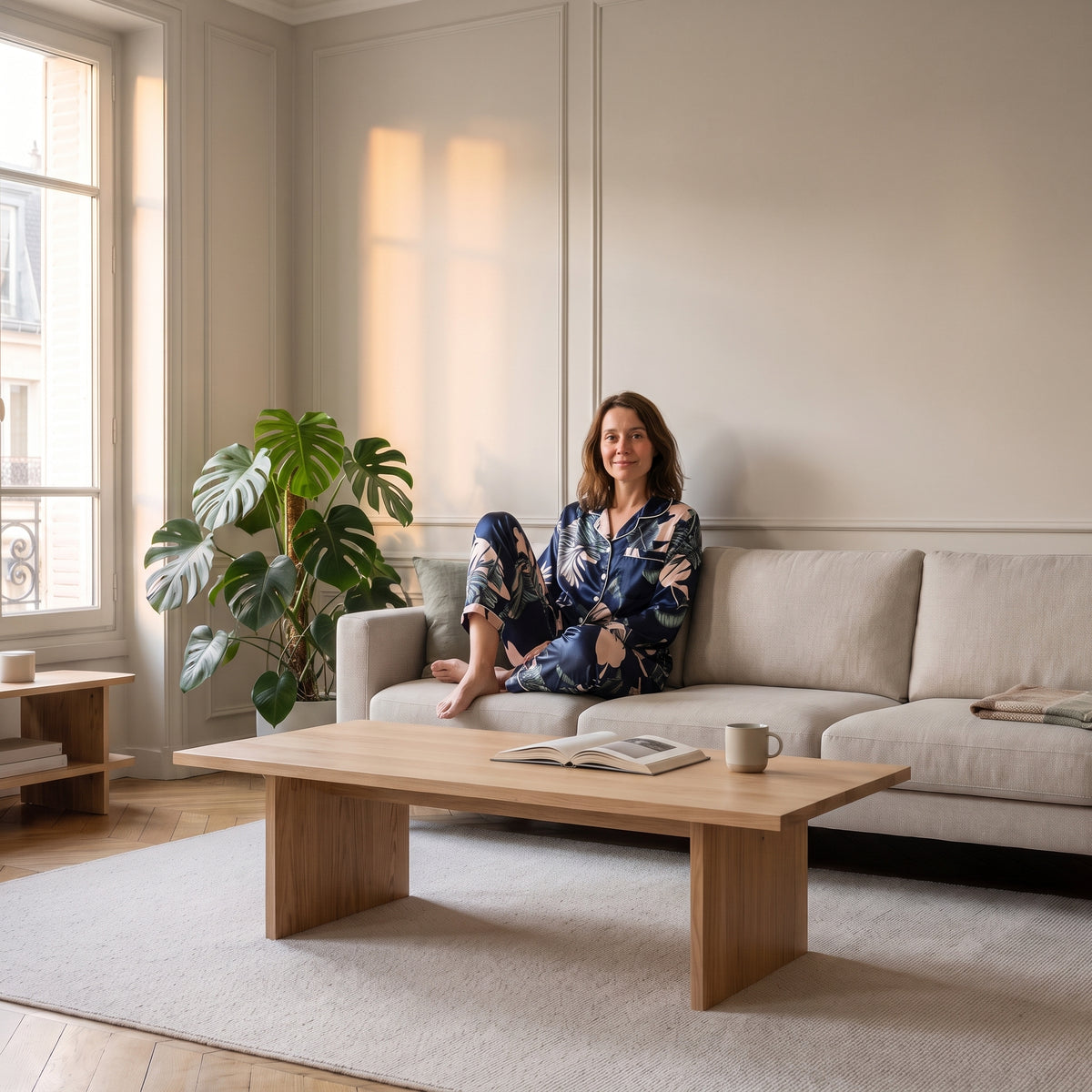 Pyjama en satin bleu marine porté assise dans un salon