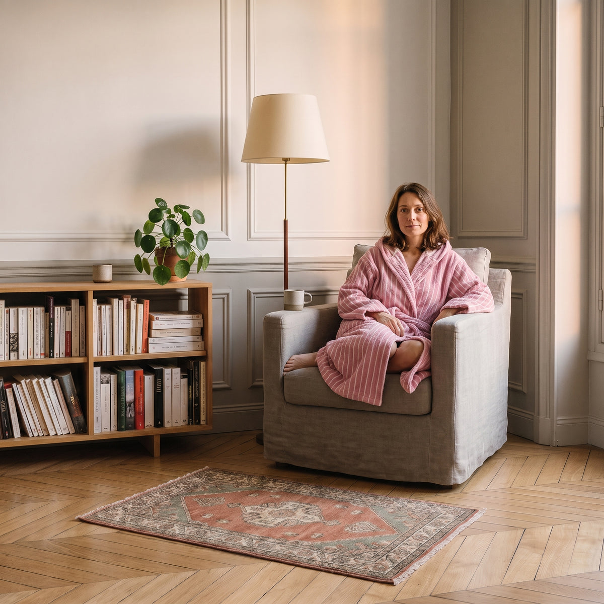 Peignoir femme rose rayé à capuche dans un coin lecture