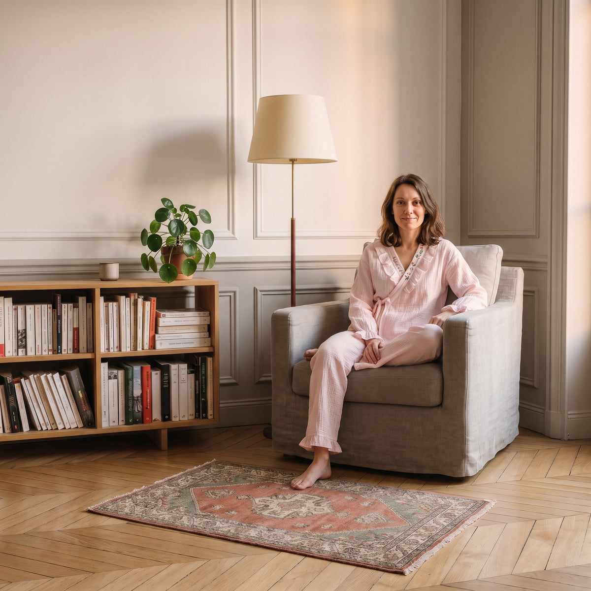 Pyjama femme cache-cœur brodé porté, assise dans un fauteuil