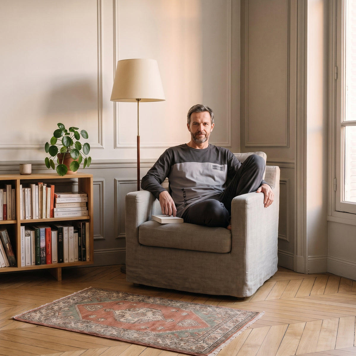 Pyjama homme gris anthracite porté assis dans le coin lecture