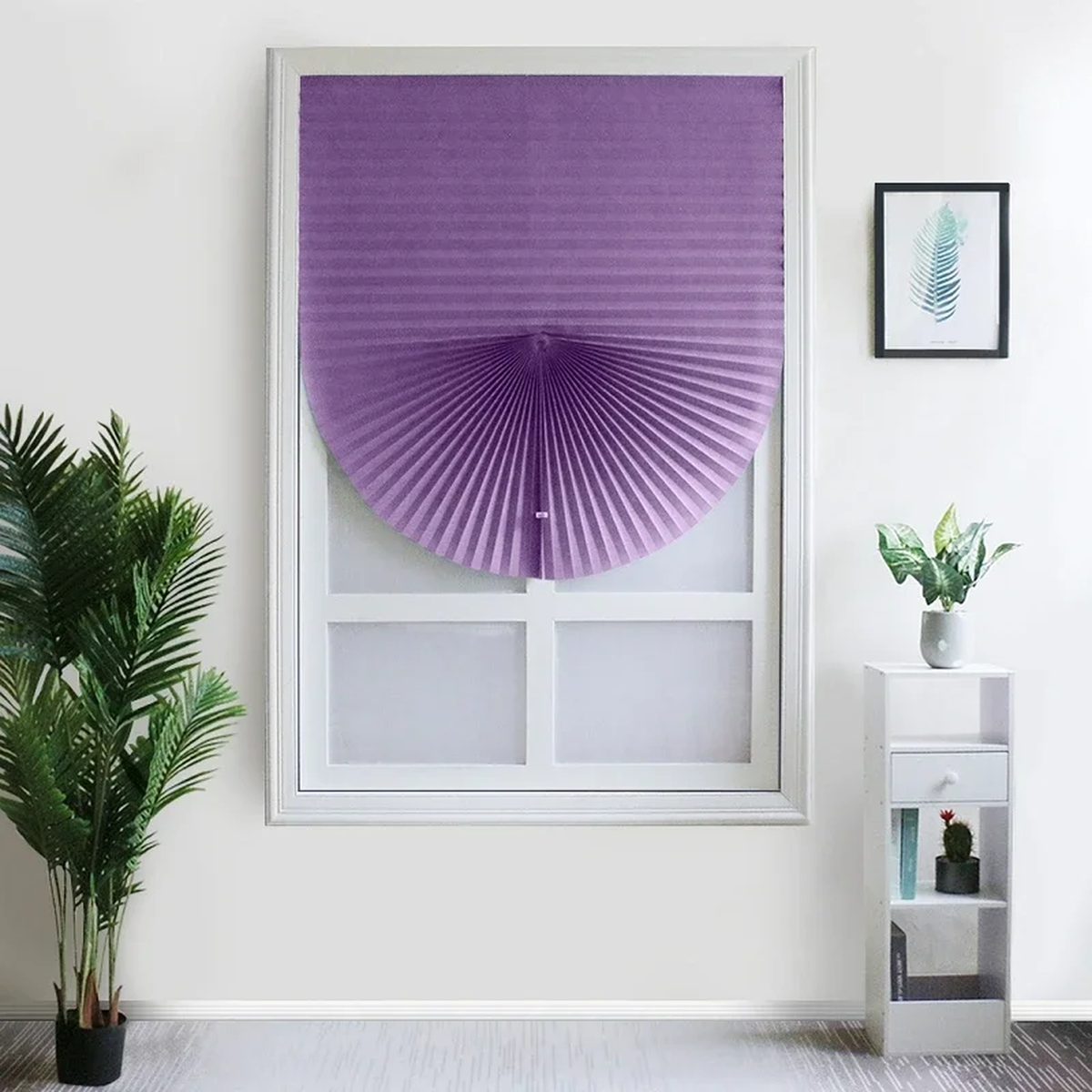 Store plissé violet remonté en éventail sur une fenêtre