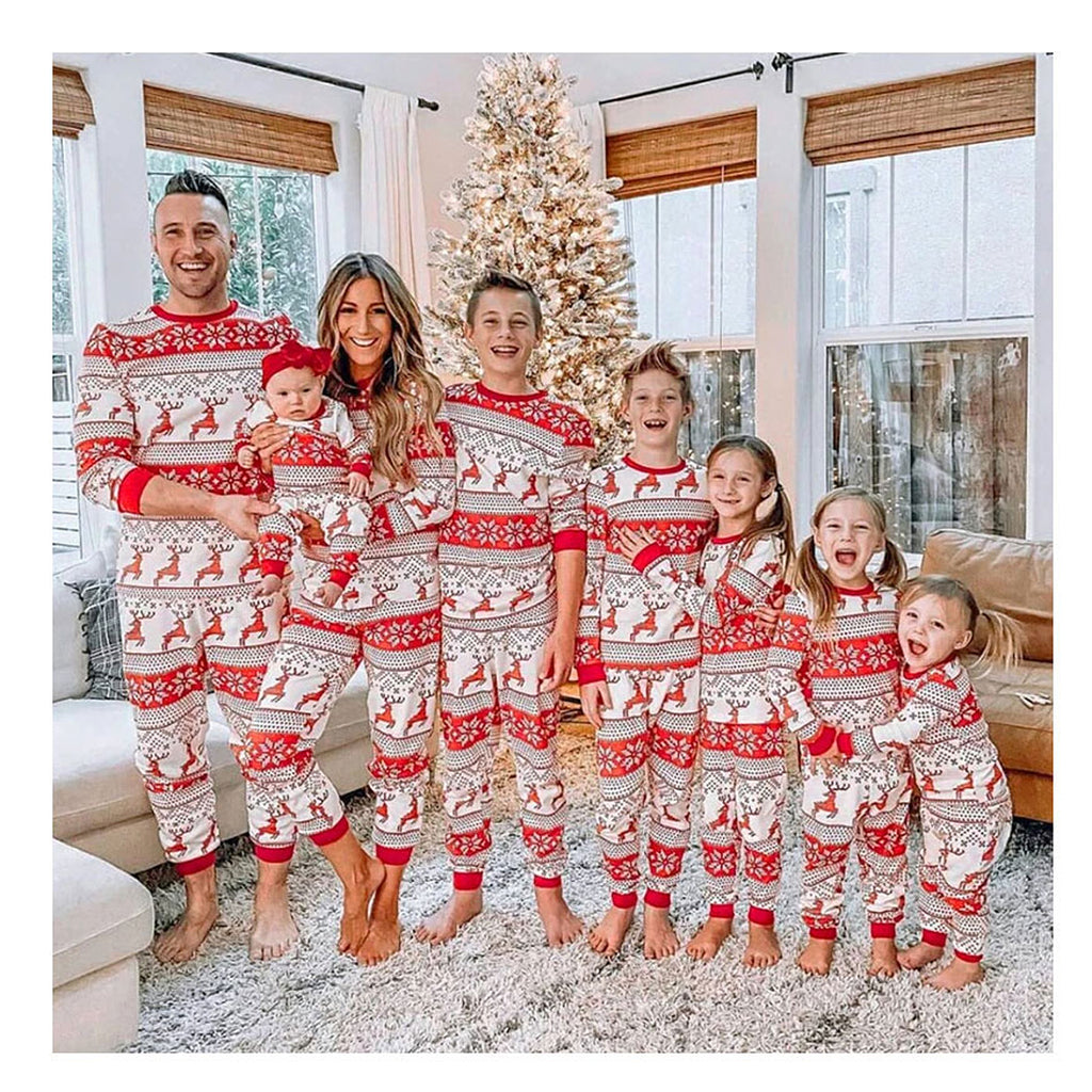Famille portant le pyjama de Noël écru et rouge à motifs rennes