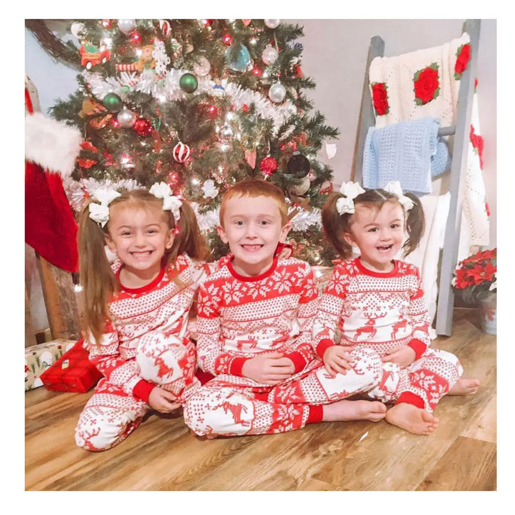 Enfants portant le pyjama de Noël écru et rouge à motifs rennes