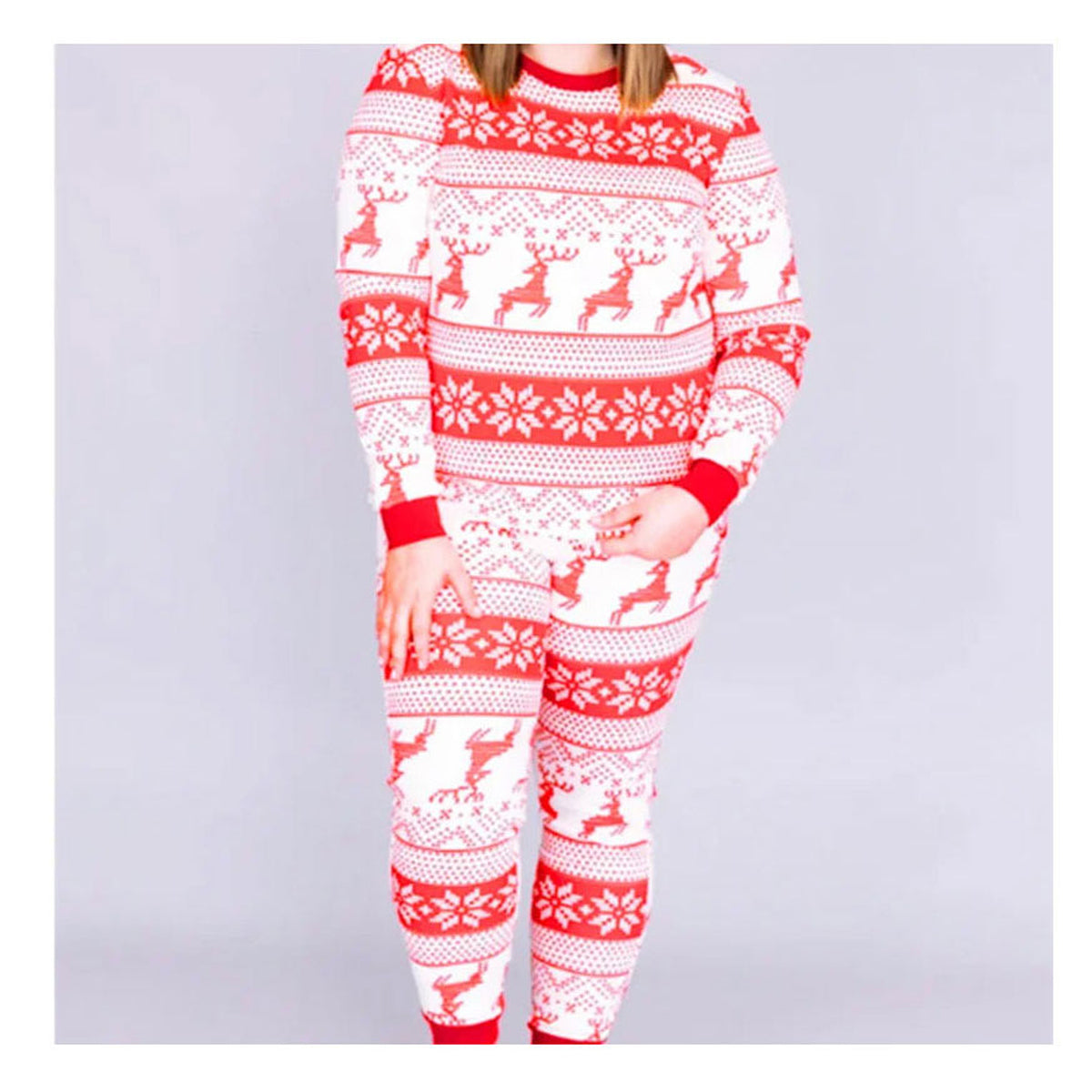 Enfant portant le pyjama de Noël écru et rouge à motifs rennes