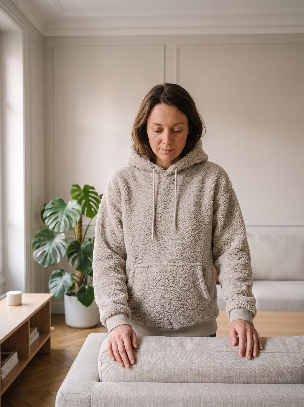 Femme du casting portant le sweat à capuche peluche gris dans le salon