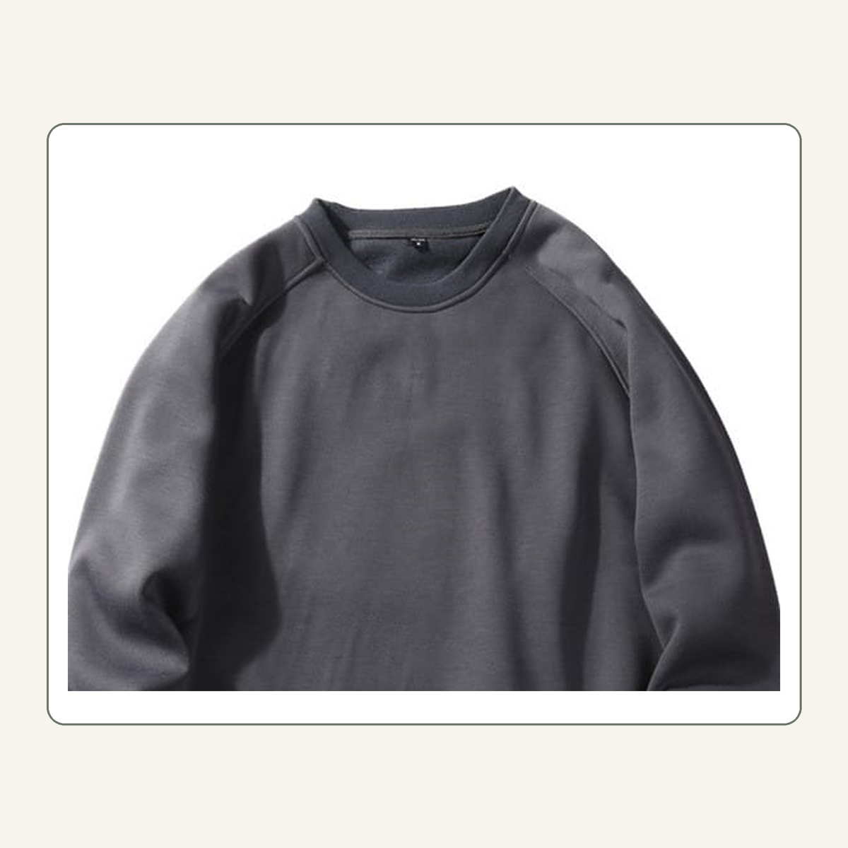 Détail du col rond et des coutures raglan du sweat homme gris foncé