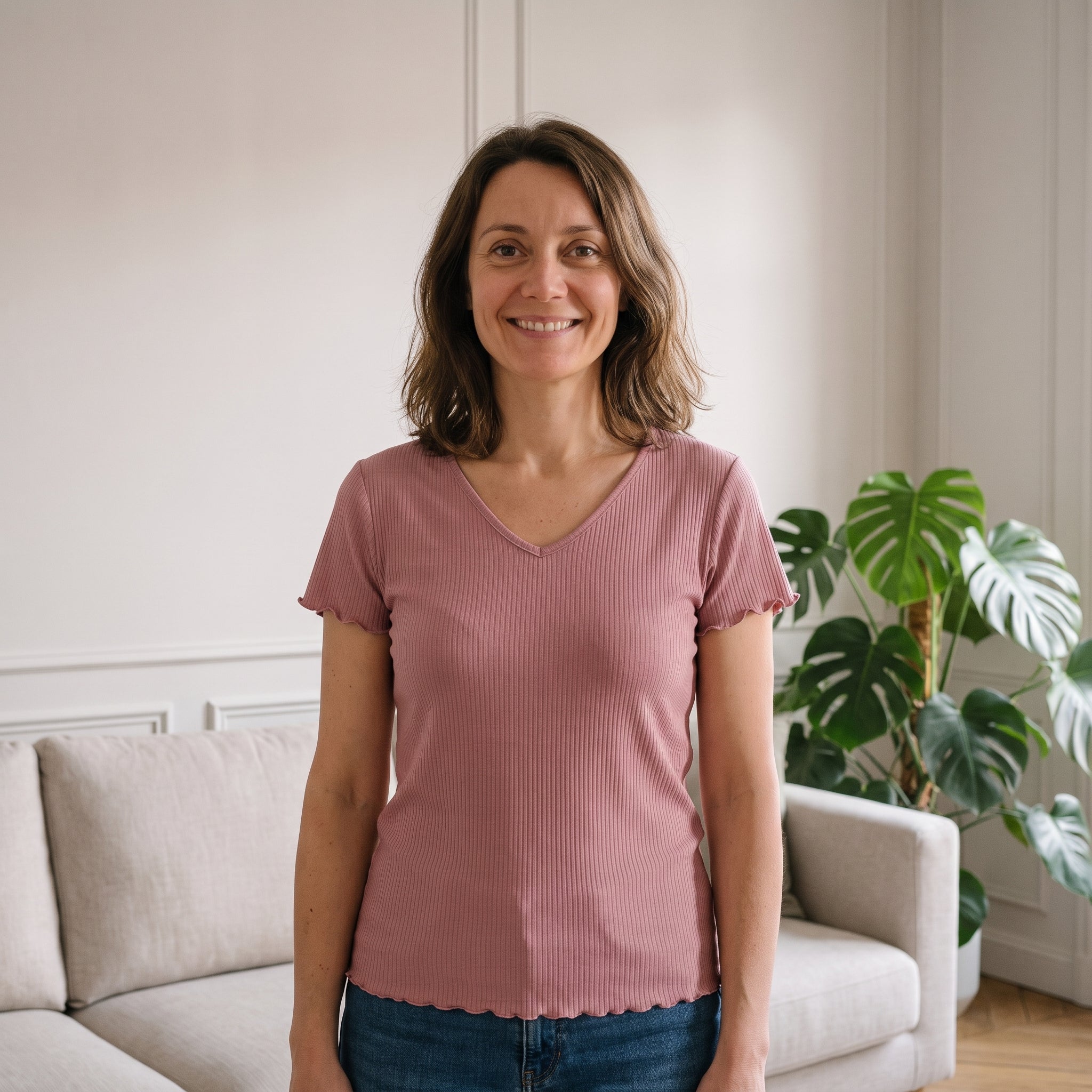Femme debout dans son salon, en t-shirt côtelé col V vieux rose Image
