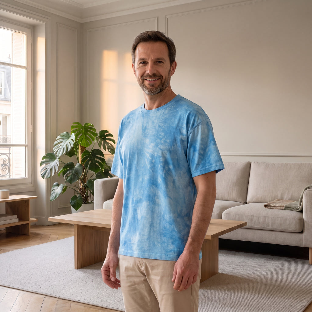 Homme en T-shirt ample tie-dye bleu ciel dans un salon lumineux