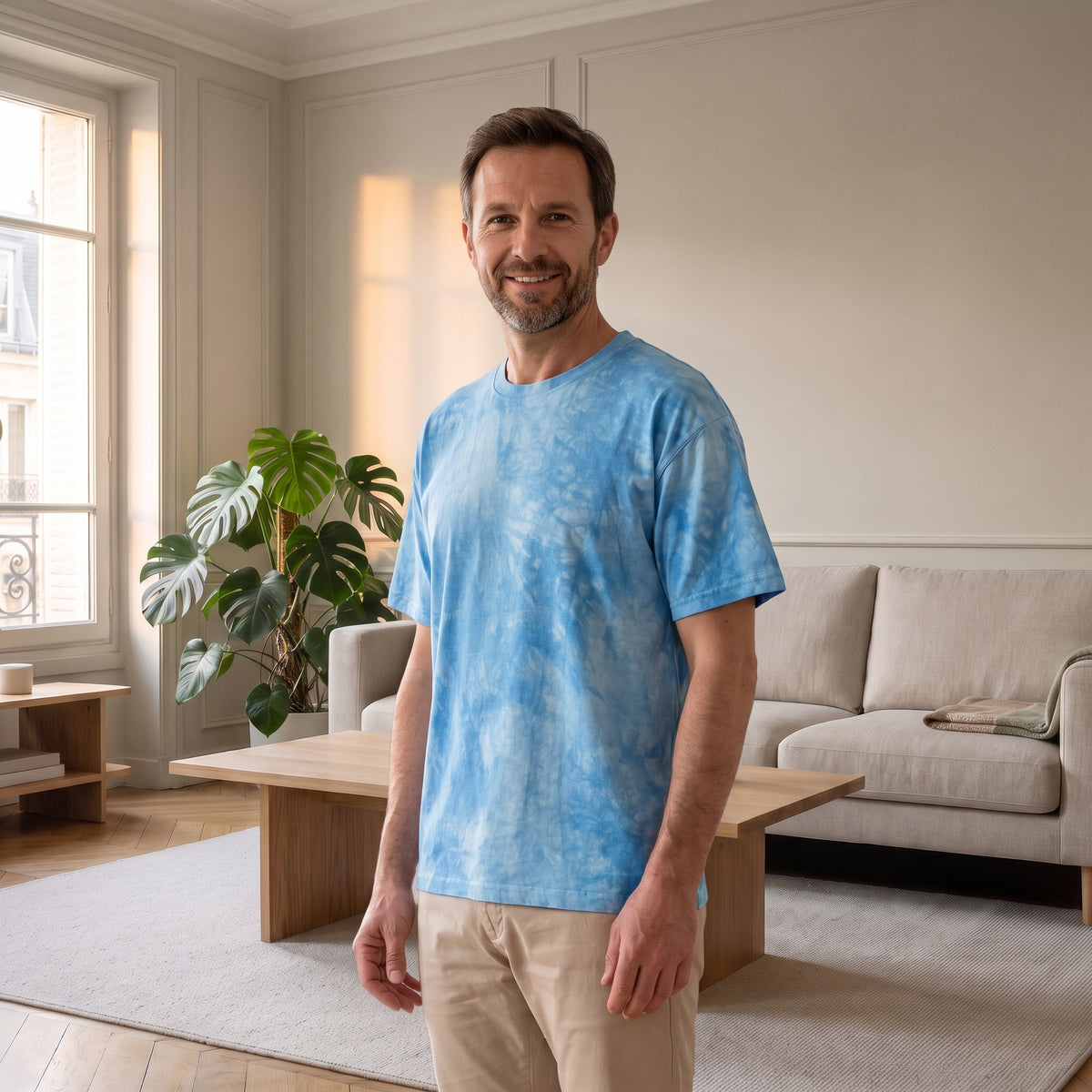 Homme en T-shirt ample tie-dye bleu ciel dans un salon lumineux