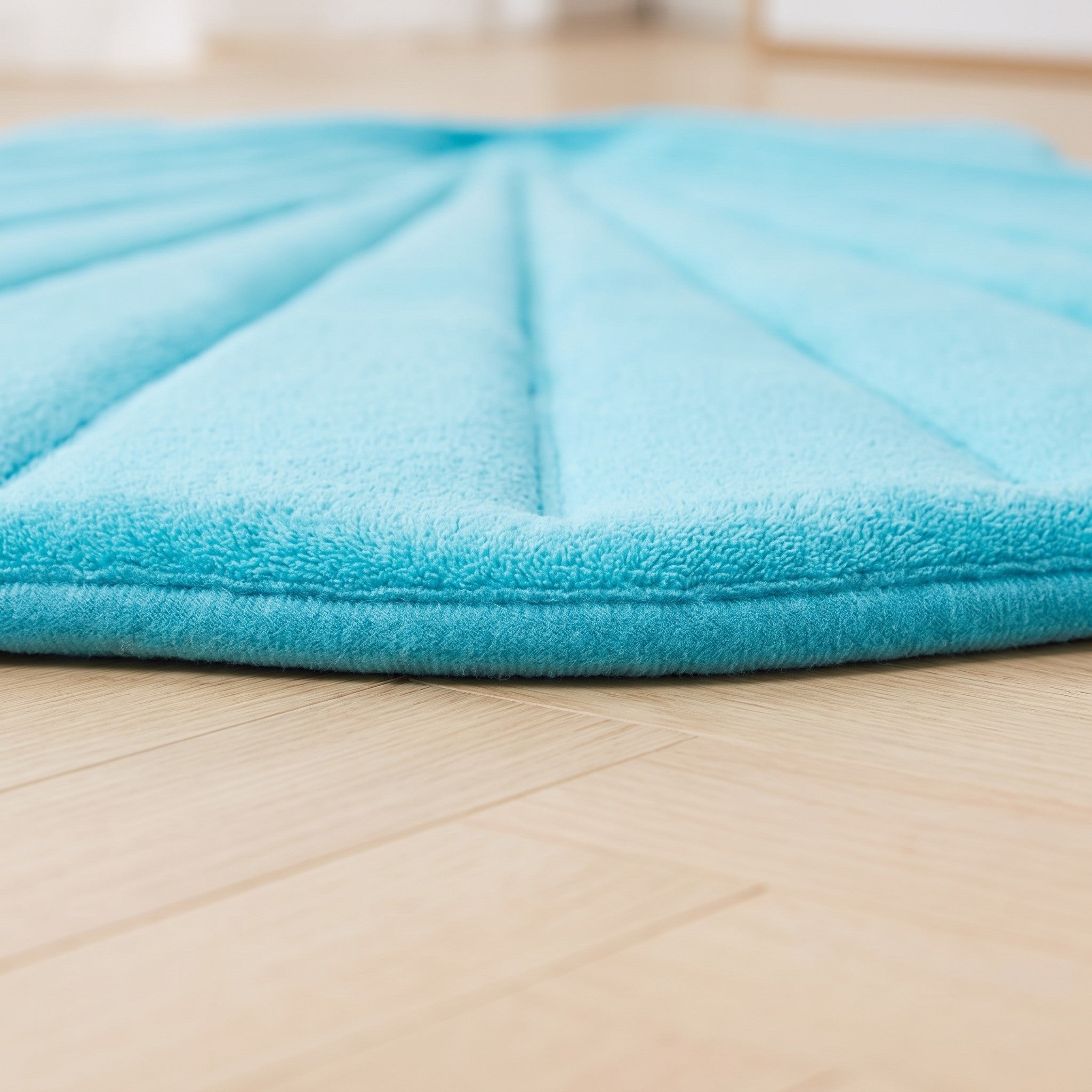 Tranche matelassée du tapis coquillage posée sur un parquet blond Image