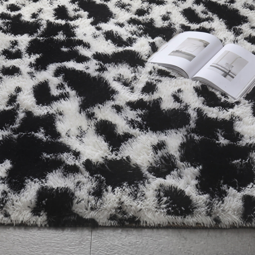 Gros plan sur les taches noires et le fond blanc casse du motif vache