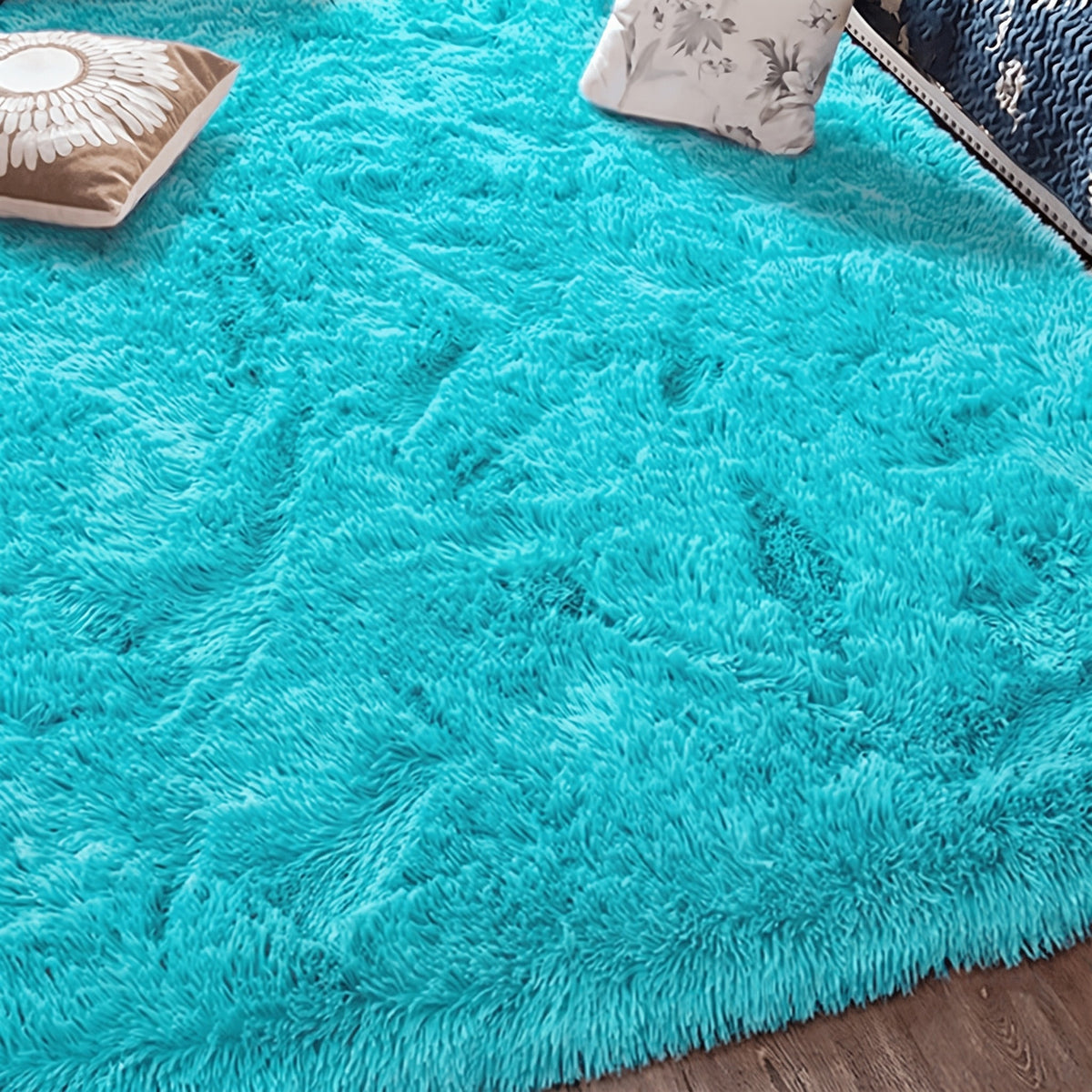 Tapis à poils longs coloris bleu turquoise, déployé au sol d'une pièce