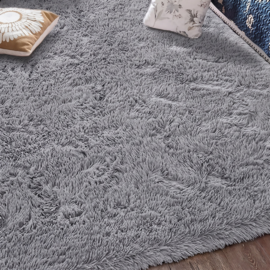 Tapis à poils longs coloris gris, déployé au sol d'une pièce