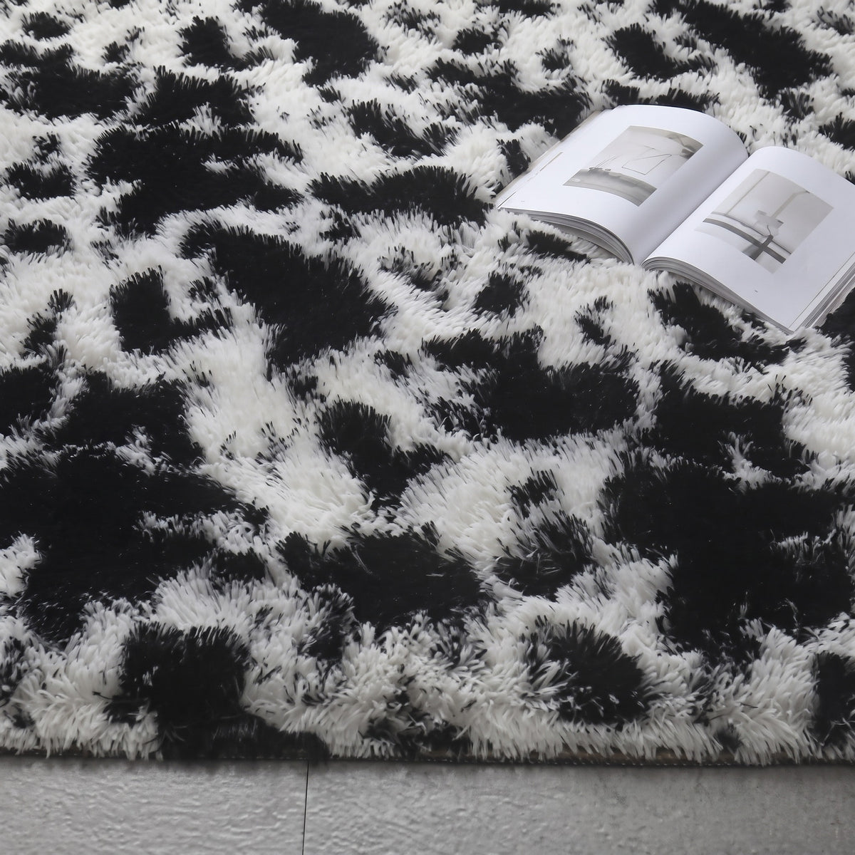 Tapis à poils longs coloris noir et blanc, déployé au sol d'une pièce