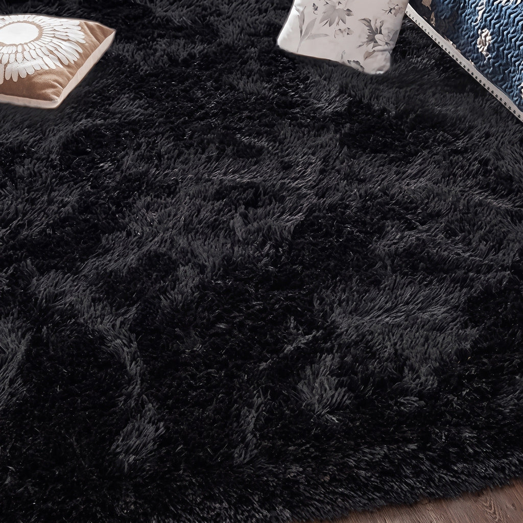 Tapis à poils longs coloris noir, déployé au sol d'une pièce