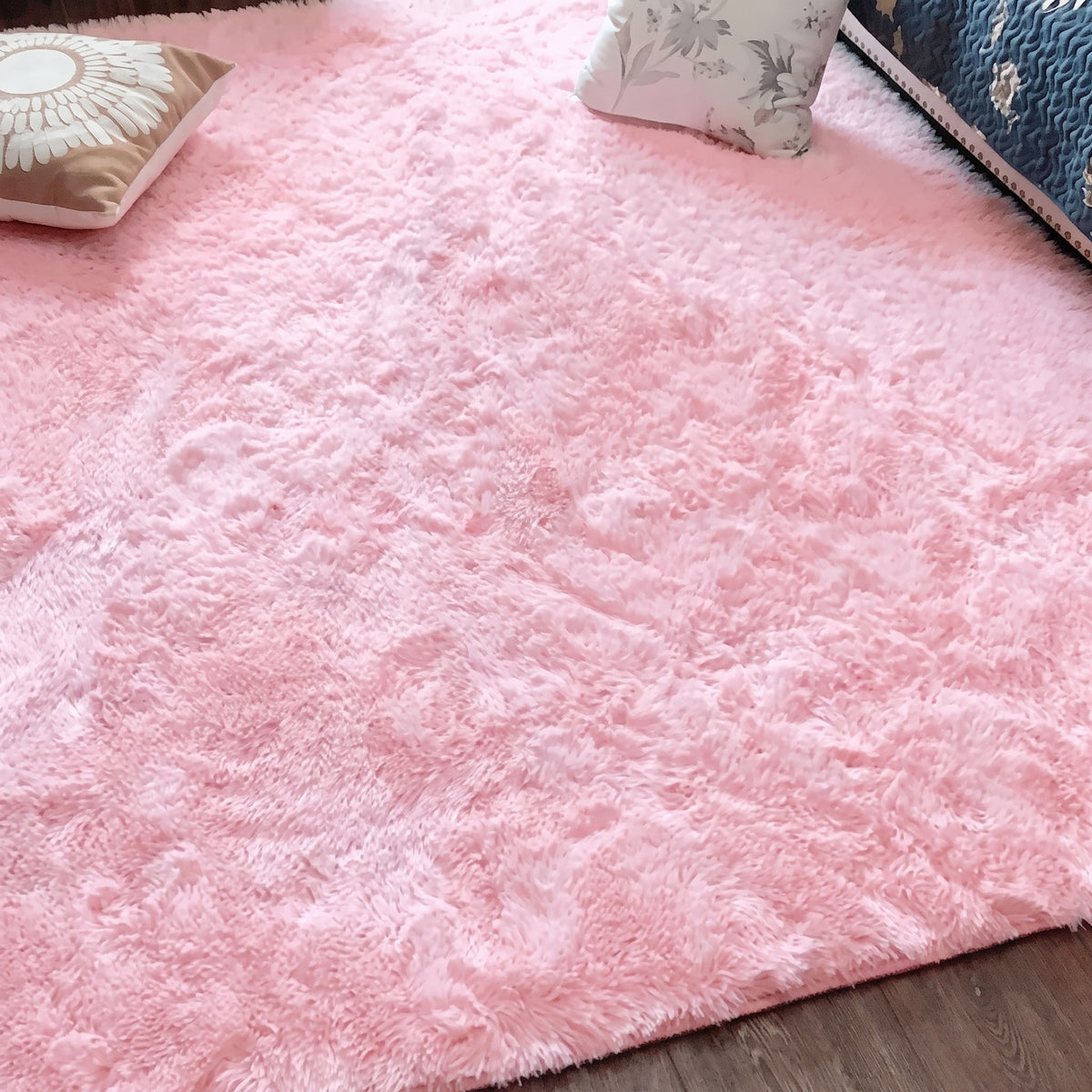 Tapis à poils longs coloris rose poudré, déployé au sol d'une pièce