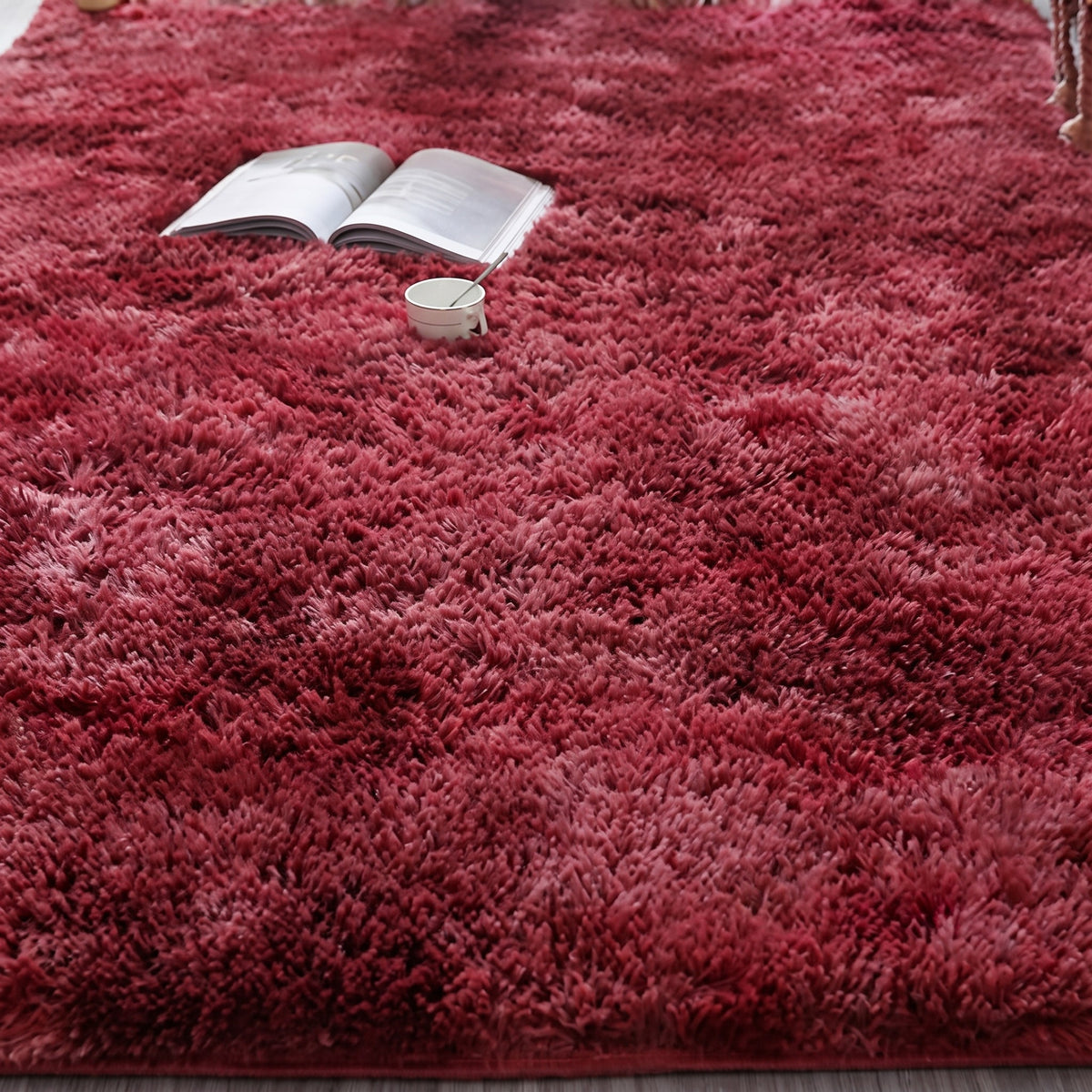 Tapis à poils longs coloris rouge profond, déployé au sol d'une pièce