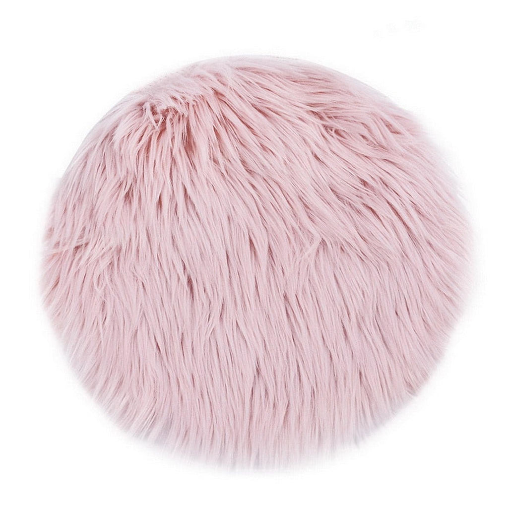 Tapis rond rose en fausse fourrure à poil long sur fond blanc
