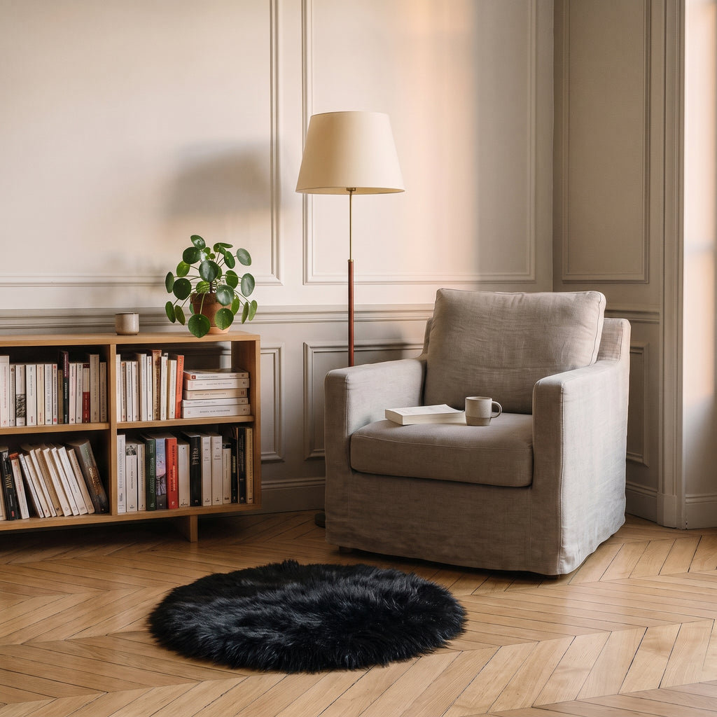 Tapis rond noir en fausse fourrure devant un fauteuil
