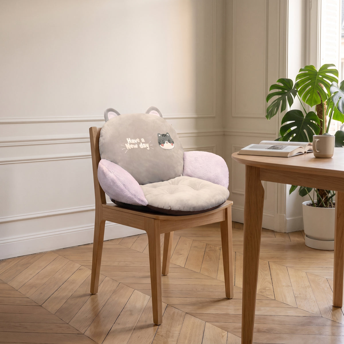Coussin de chaise taupe à motif chat, installe sur une chaise en bois du coin repas