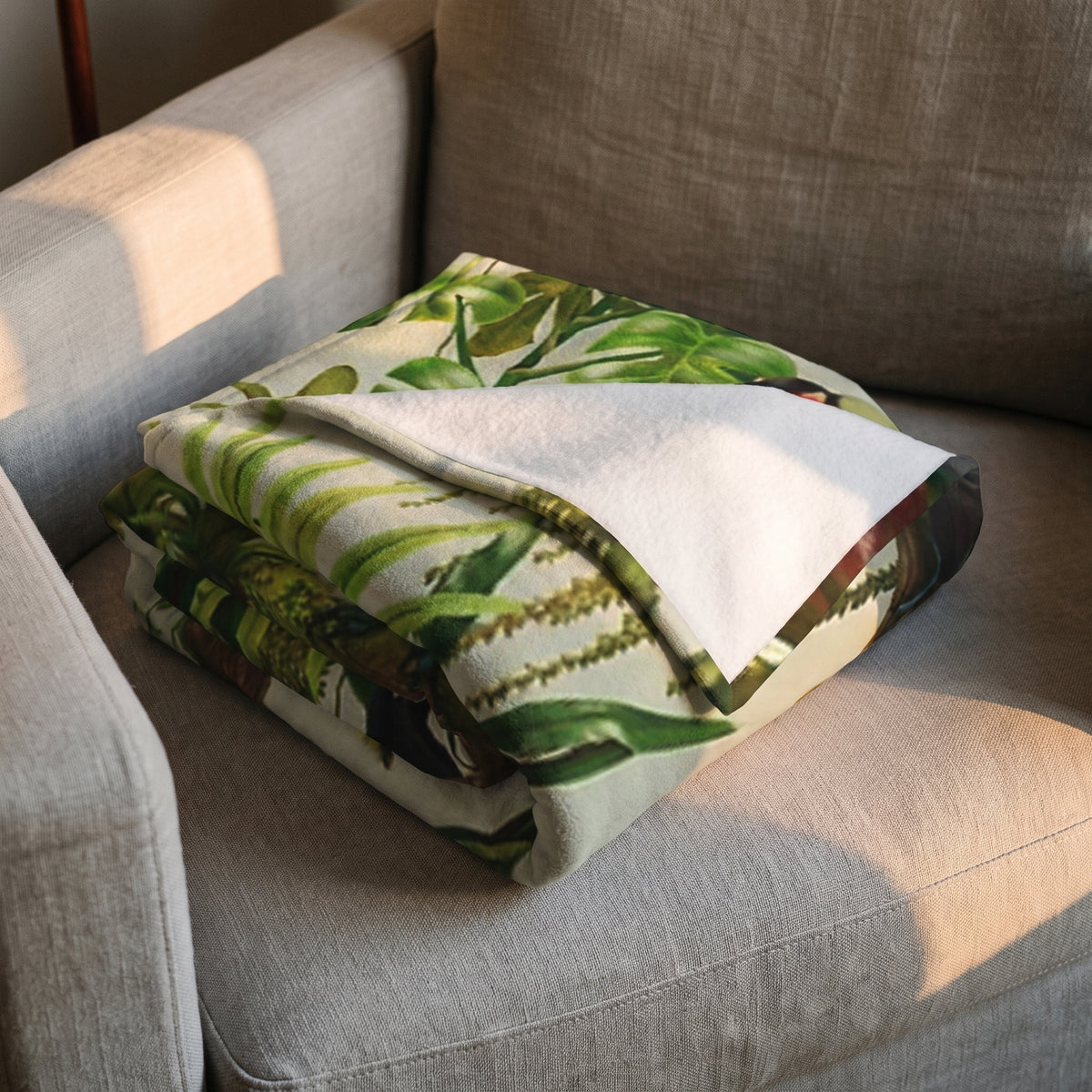 Plaid polaire toucans et jungle plié, l'imprimé et l'envers blanc côte à côte