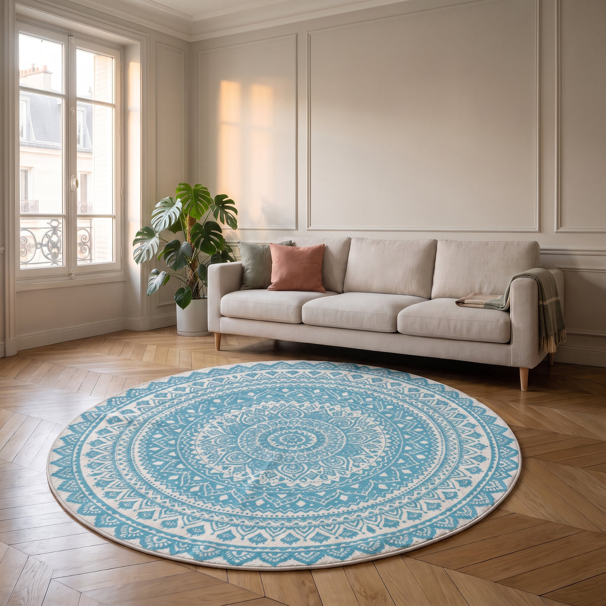 Tapis rond mandala turquoise et blanc posé devant un canapé dans un salon