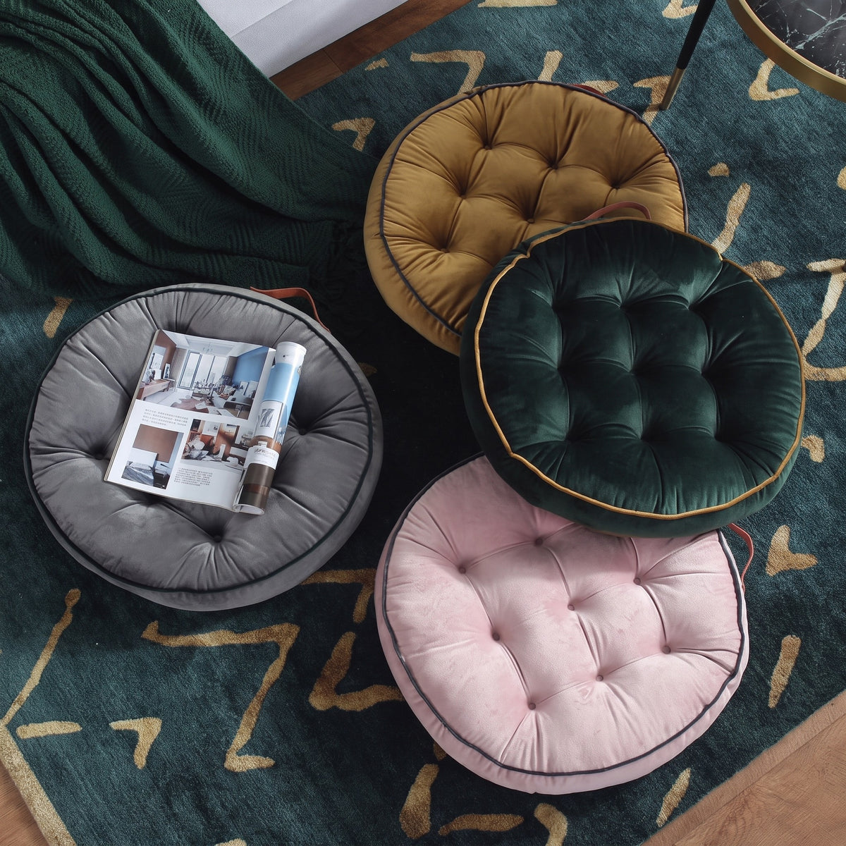 Coussin de sol rond gris avec un magazine déco posé dessus, dans un salon chaleureux