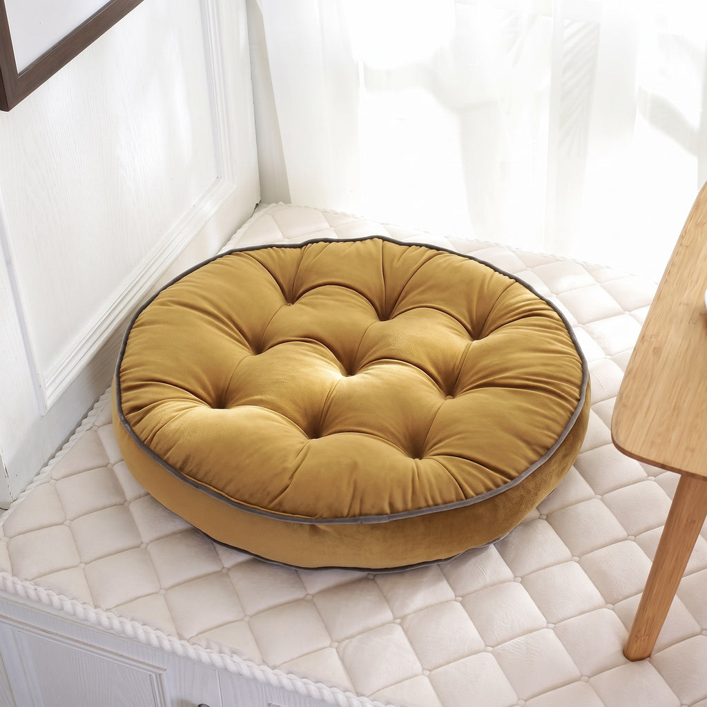 Coussin de sol rond façon tatami coloris jaune moutarde, posé au sol près d'une fenêtre